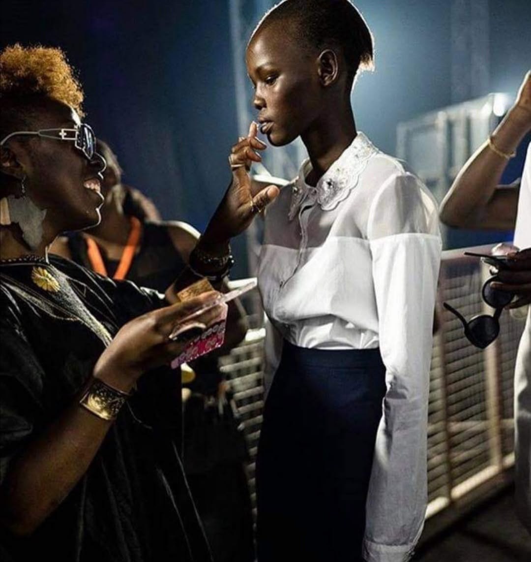 Nallah Balassama Sangaré retouche le maquillage d’un mannequin en coulisses d’un défilé